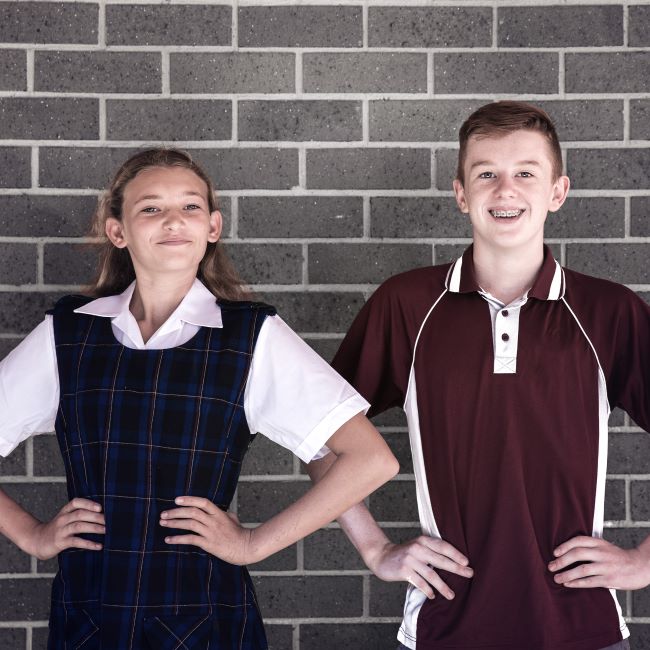 Two students with hands on hips looking proud and assertive