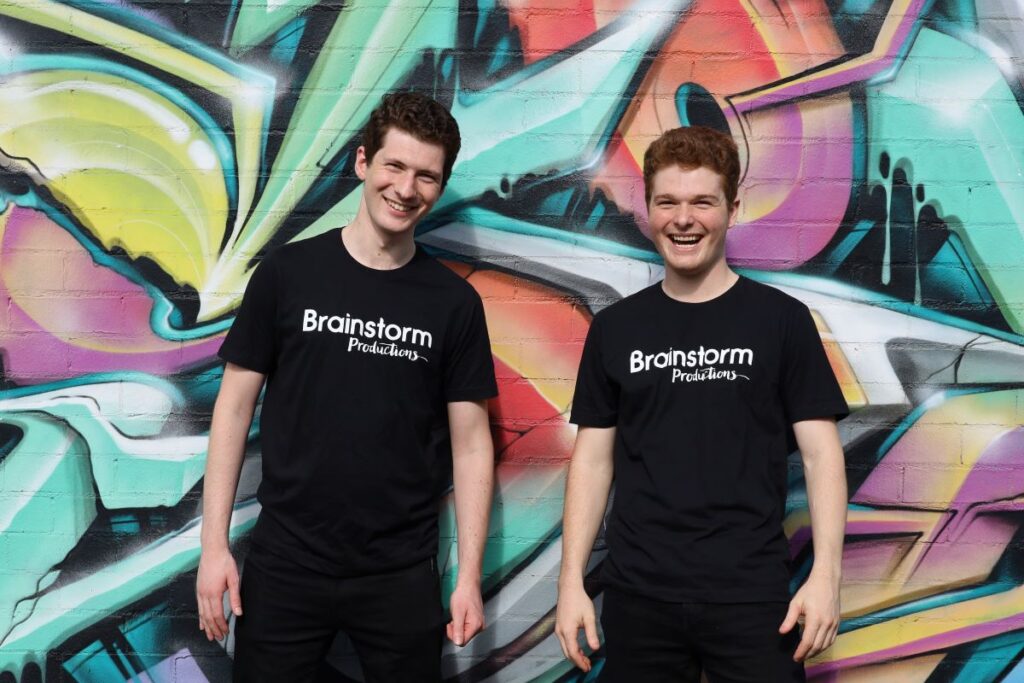 Promo image of two Brainstorm Productions actors in front of a colourful street art wall