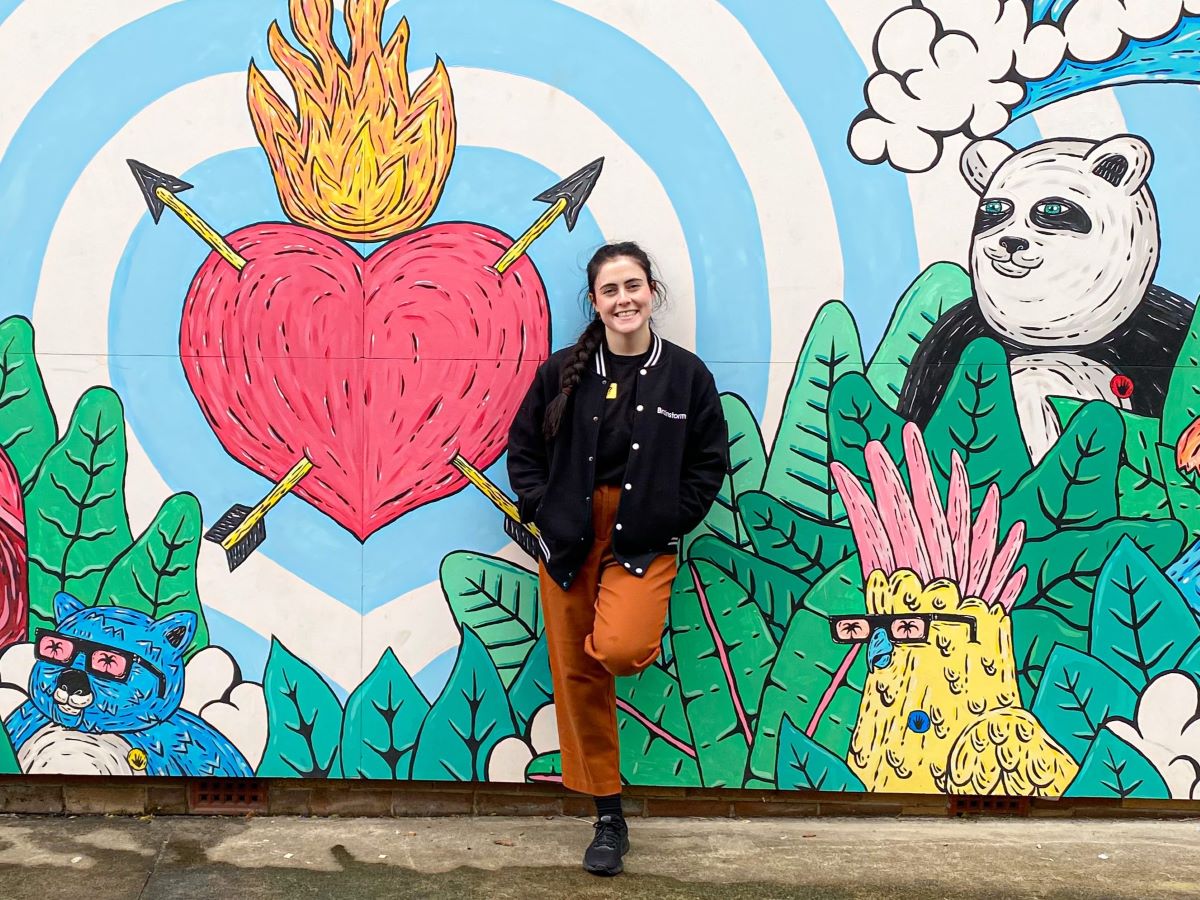 A Sydney based Brainstorm Productions actor in front of a colourful mural at St Augustine's College Brookside NSW